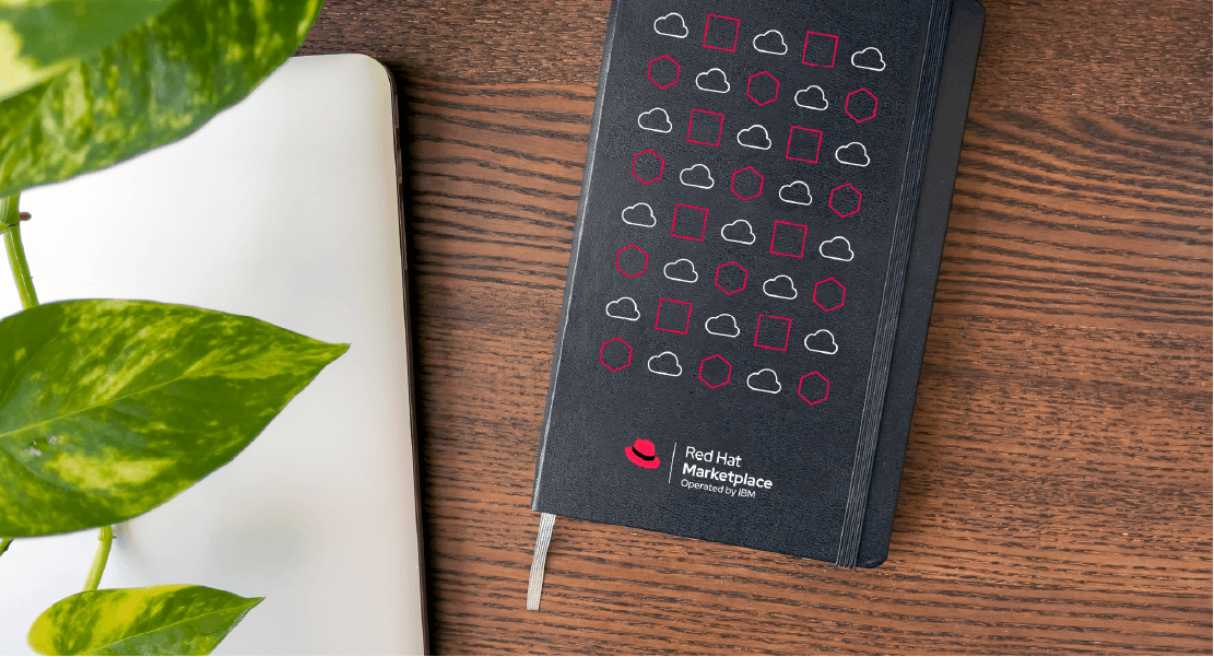 A notebook with the Red Hat Marketplace logo and a pattern of red hat icon printed on the cover